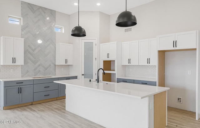 kitchen with decorative light fixtures, white cabinets, and gray cabinets