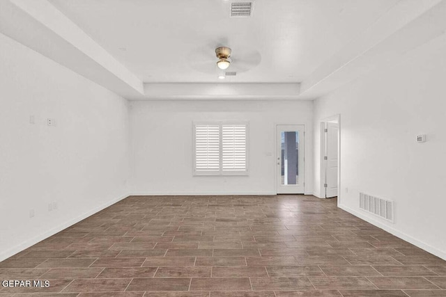 unfurnished room featuring ceiling fan and a tray ceiling