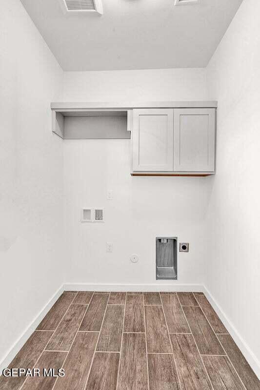 clothes washing area with dark hardwood / wood-style flooring, electric dryer hookup, washer hookup, and gas dryer hookup