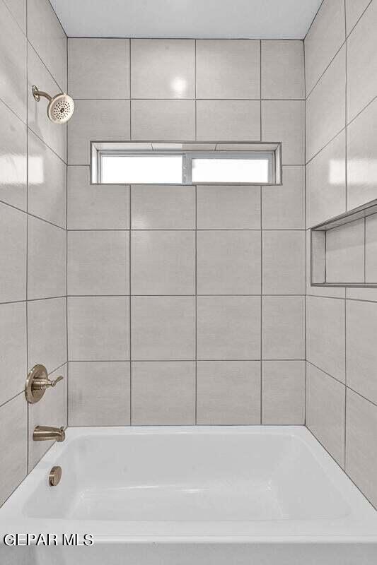 bathroom featuring tiled shower / bath