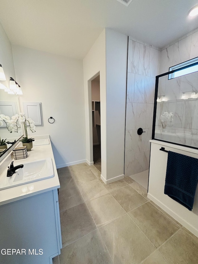 full bath featuring double vanity, a sink, baseboards, and a walk in shower