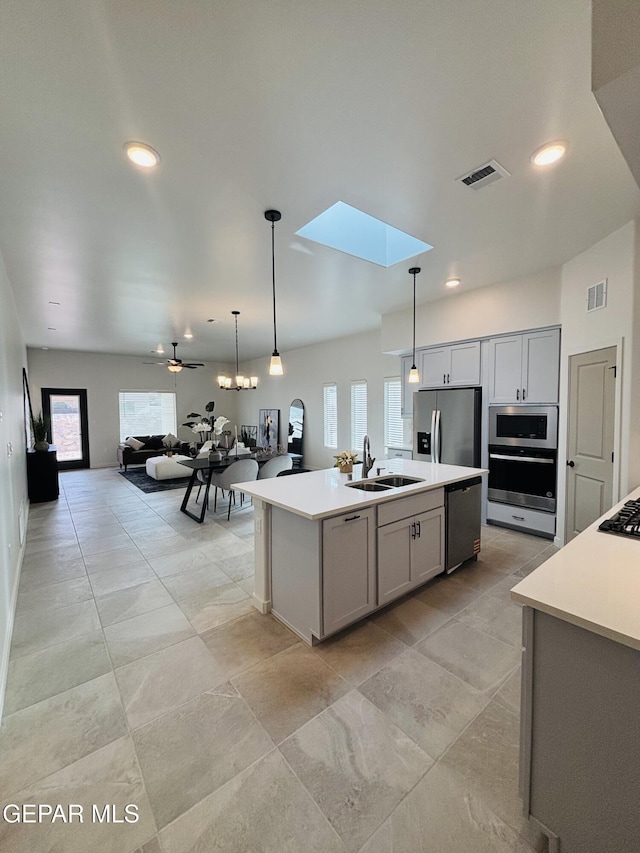 kitchen with appliances with stainless steel finishes, visible vents, a skylight, and a sink