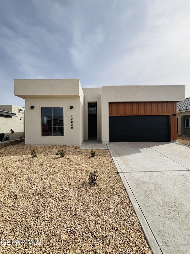 view of front of property featuring stucco siding, driveway, and a garage