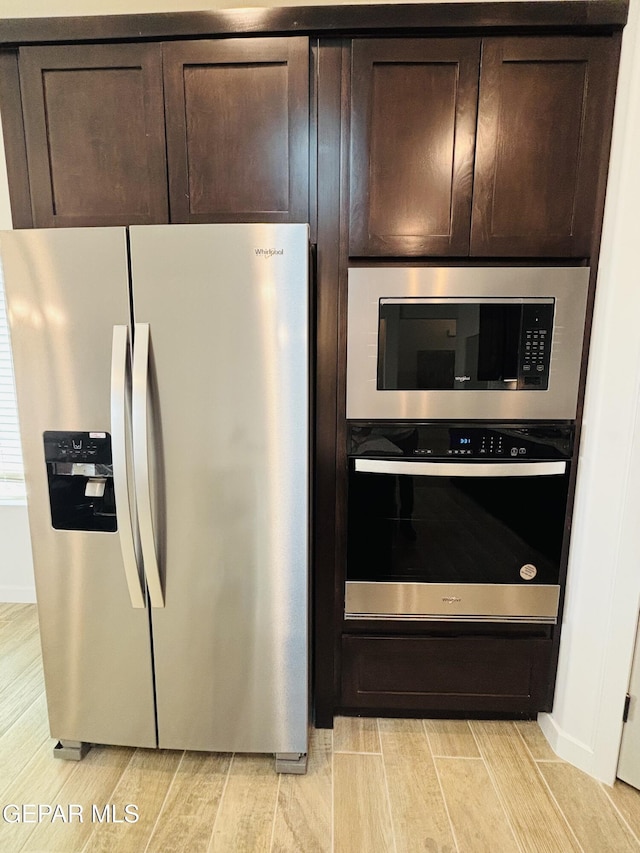 kitchen featuring built in microwave, wall oven, stainless steel fridge, and wood finish floors