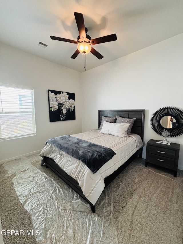 carpeted bedroom featuring a ceiling fan, baseboards, and visible vents