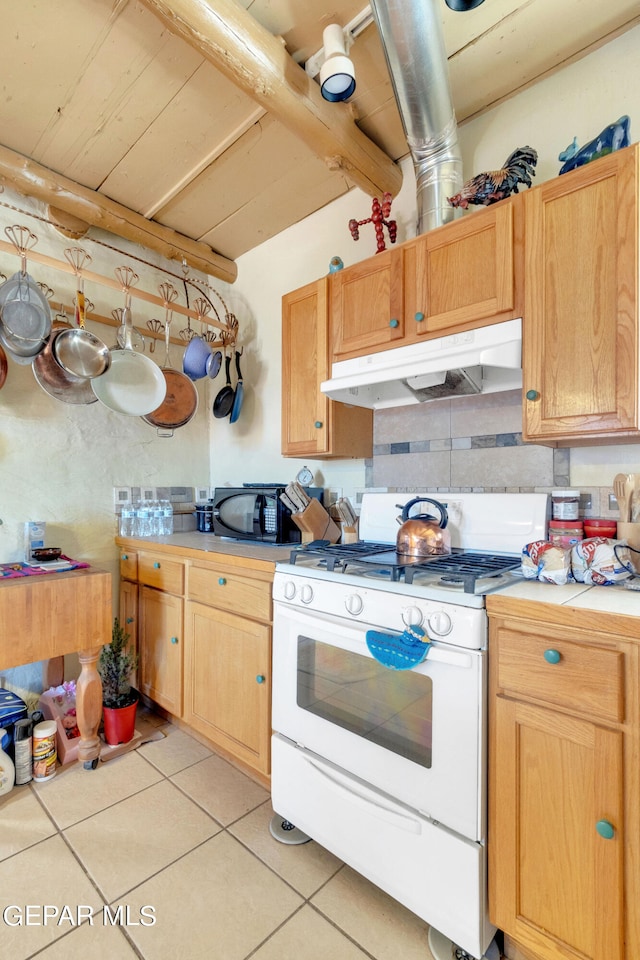 kitchen featuring light tile floors and white gas stove