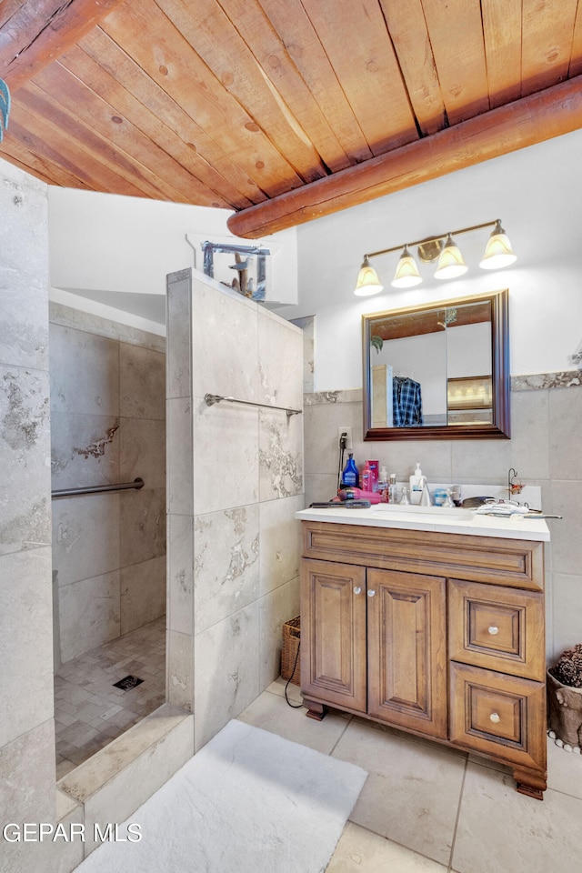 bathroom featuring tile walls, a tile shower, tile floors, wooden ceiling, and dual vanity