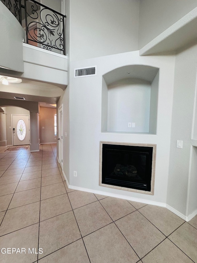 interior space featuring light tile flooring and a towering ceiling