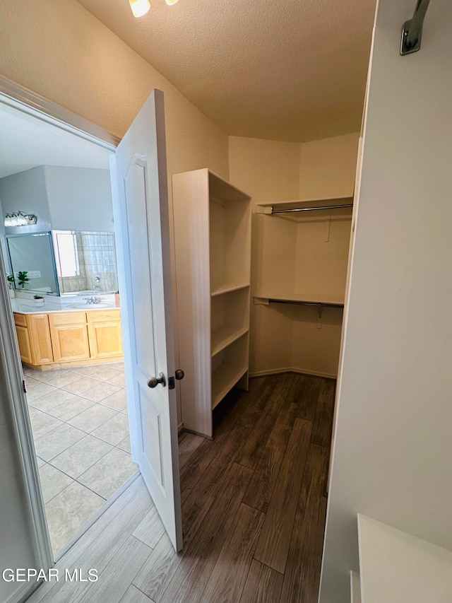 walk in closet featuring light tile floors