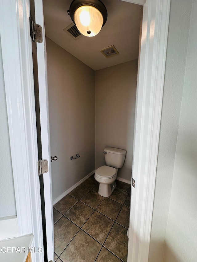 bathroom featuring toilet and tile floors