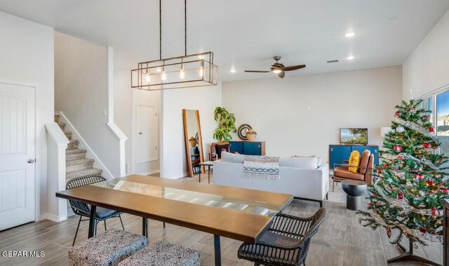 dining area featuring light hardwood / wood-style floors and ceiling fan with notable chandelier