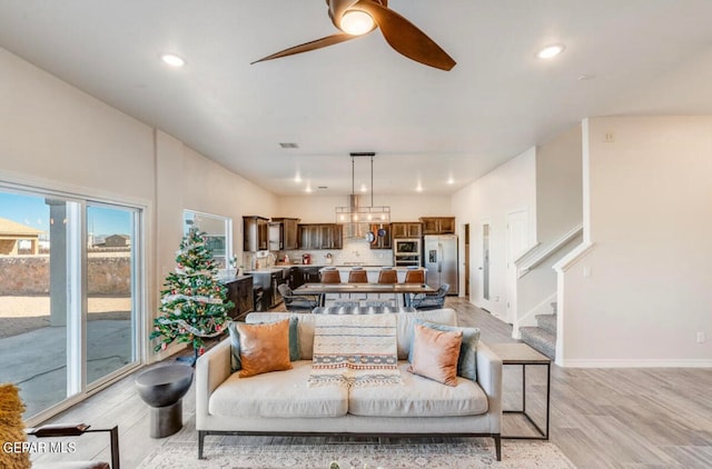 living room with ceiling fan and light hardwood / wood-style flooring