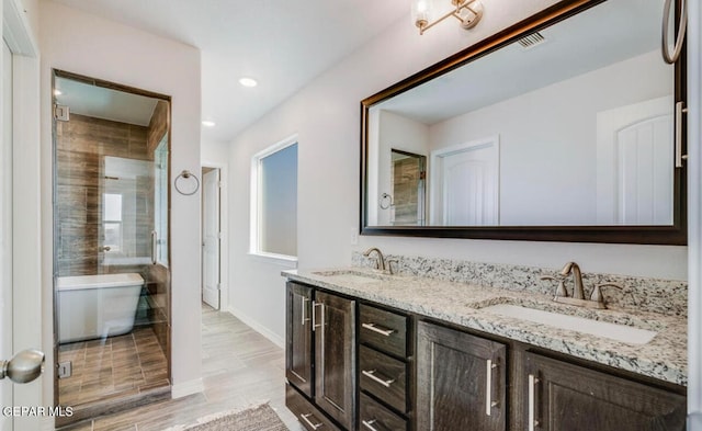 bathroom featuring double sink, a washtub, and oversized vanity