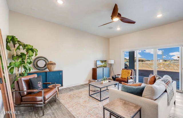 living room with ceiling fan and light hardwood / wood-style flooring