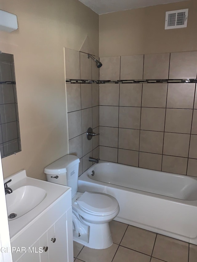 full bathroom with tiled shower / bath combo, tile flooring, toilet, and vanity