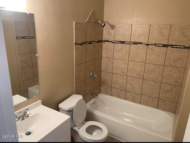 full bathroom with toilet, vanity, and tiled shower / bath