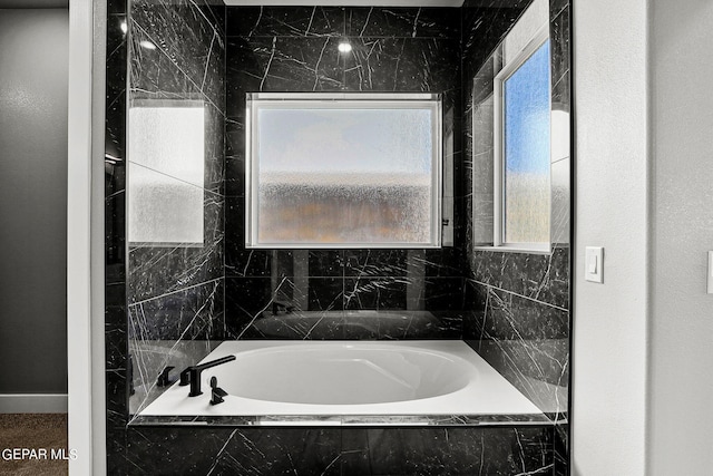 bathroom featuring a relaxing tiled tub