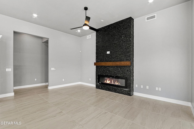 unfurnished living room with ceiling fan and a fireplace