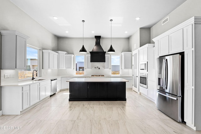 kitchen featuring a kitchen island, decorative light fixtures, sink, stainless steel appliances, and white cabinets