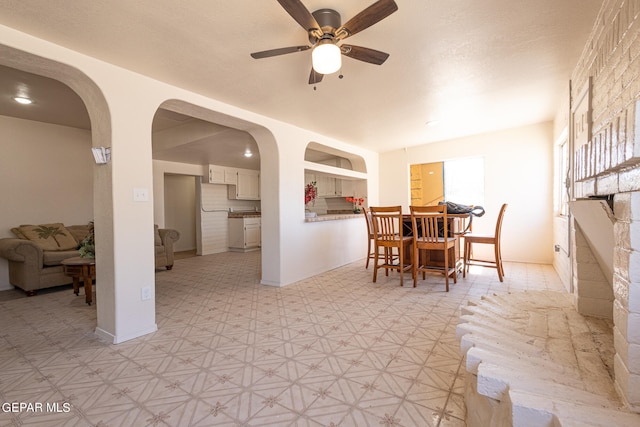 dining space with ceiling fan, built in features, and light tile flooring