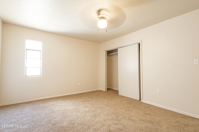 unfurnished bedroom with carpet, a closet, and ceiling fan