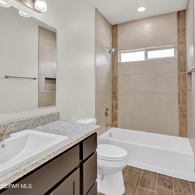 full bathroom with vanity, tiled shower / bath combo, tile flooring, and toilet