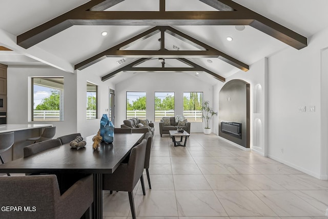 dining area with vaulted ceiling with beams