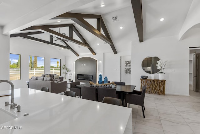 dining room with beamed ceiling and high vaulted ceiling