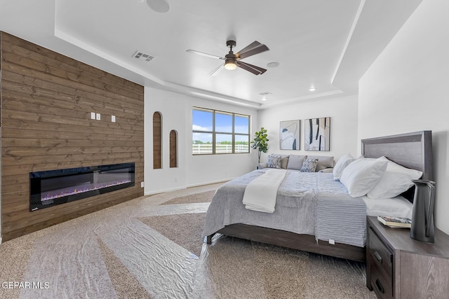 bedroom featuring carpet flooring, ceiling fan, and a tray ceiling