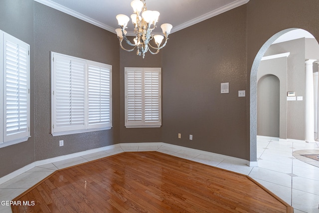 spare room with light hardwood / wood-style floors, an inviting chandelier, and ornamental molding