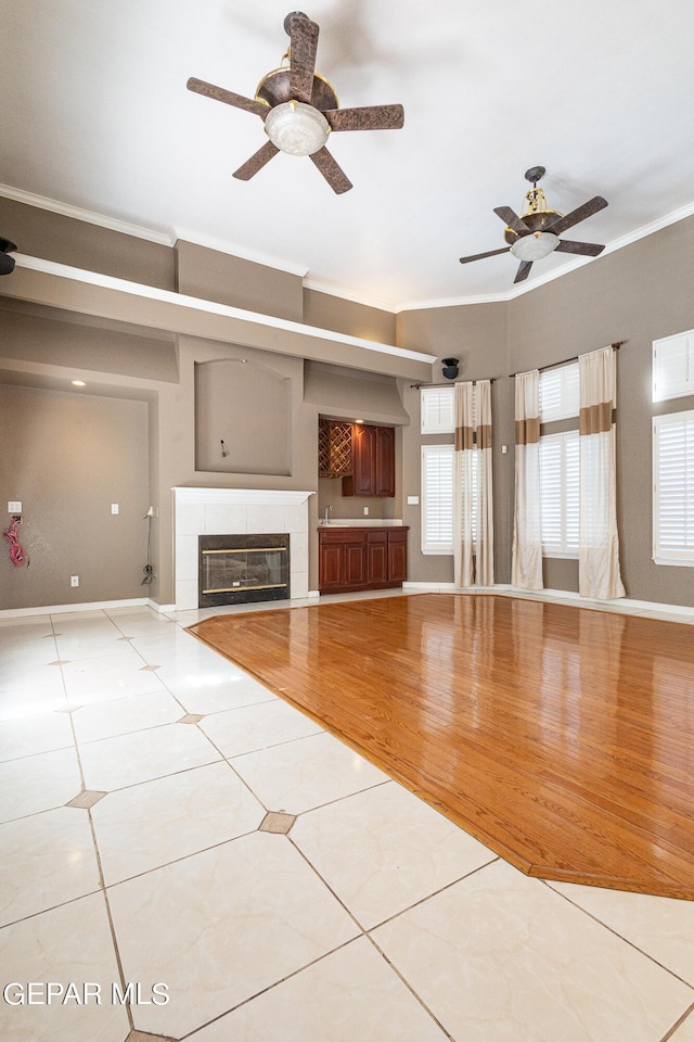 18 Via Placita, El Paso, TX 79927 - unfurnished living room featuring ornamental molding, a ceiling fan, tile patterned flooring, a fireplace, and baseboards