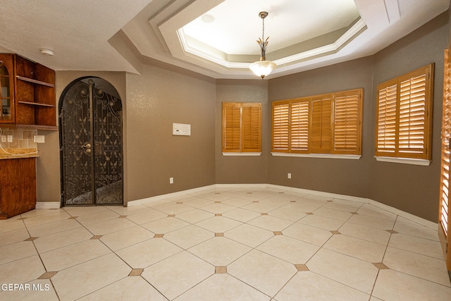 unfurnished room featuring a raised ceiling