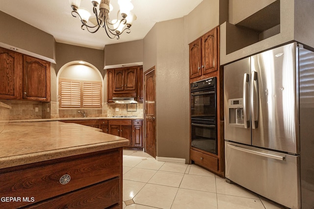 18 Via Placita, El Paso, TX 79927 - kitchen with stainless steel refrigerator with ice dispenser, a chandelier, decorative backsplash, light tile patterned floors, and light countertops