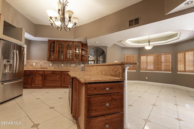 18 Via Placita, El Paso, TX 79927 - kitchen with stainless steel fridge, tasteful backsplash, glass insert cabinets, light tile patterned flooring, and a raised ceiling