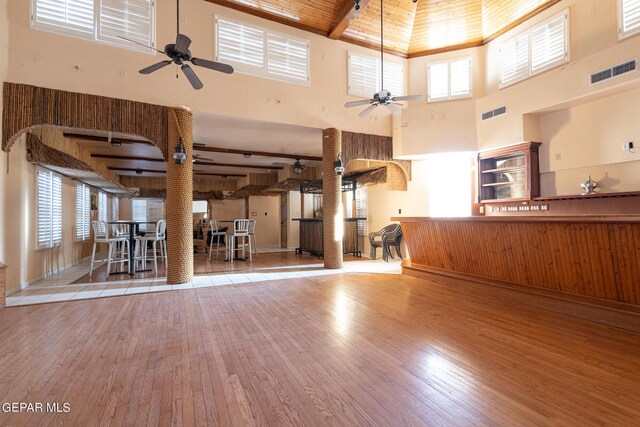 18 Via Placita, El Paso, TX 79927 - unfurnished living room with a ceiling fan, a towering ceiling, wood finished floors, decorative columns, and wood ceiling