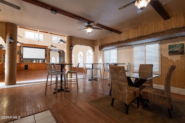 dining space with beam ceiling, ceiling fan, and wood-type flooring