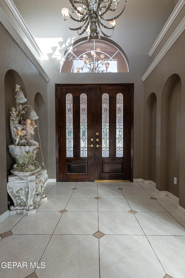 18 Via Placita, El Paso, TX 79927 - tiled entrance foyer featuring a chandelier, arched walkways, baseboards, and ornamental molding