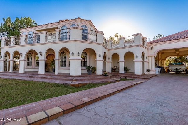 back house at dusk with a balcony