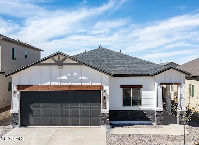 view of front of house with a garage, driveway, a shingled roof, stone siding, and board and batten siding