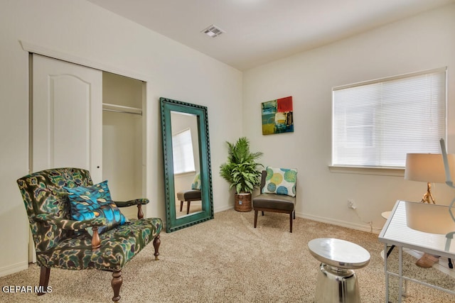 living area featuring a wealth of natural light and light carpet