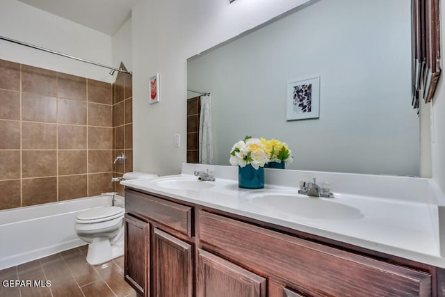 full bathroom with double sink vanity, toilet, and shower / bath combo with shower curtain