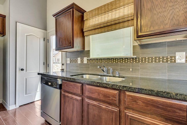 kitchen featuring dishwasher, tasteful backsplash, hardwood / wood-style flooring, dark stone countertops, and sink