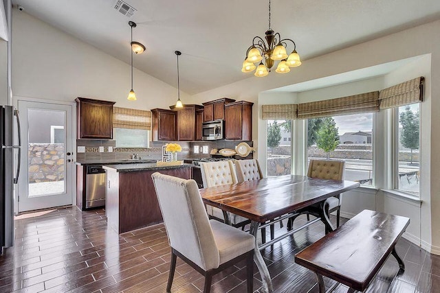 dining room with sink, high vaulted ceiling, a notable chandelier, and dark wood-type flooring