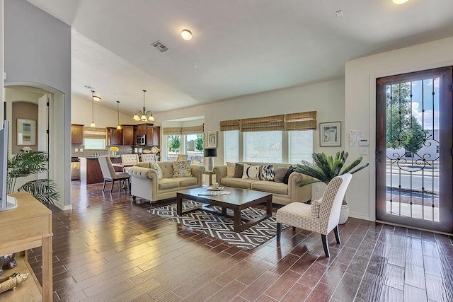 living room with dark hardwood / wood-style floors, high vaulted ceiling, and a chandelier