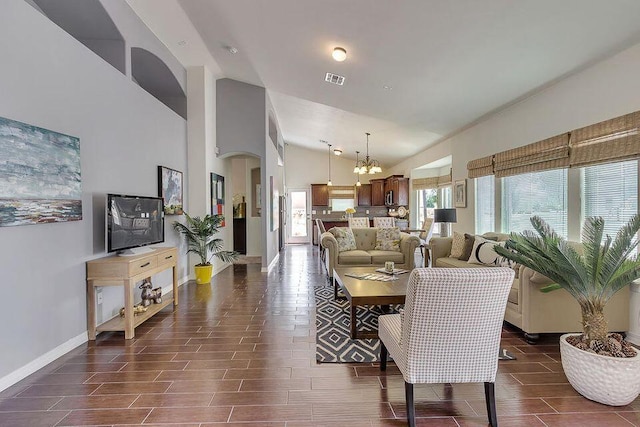 living room featuring high vaulted ceiling and an inviting chandelier