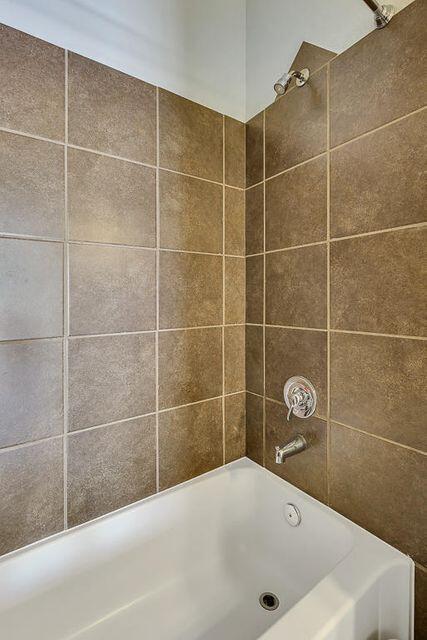 bathroom featuring tiled shower / bath