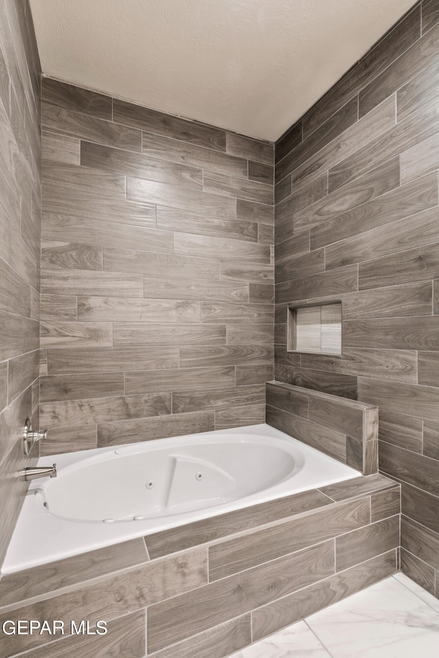 bathroom with a relaxing tiled tub