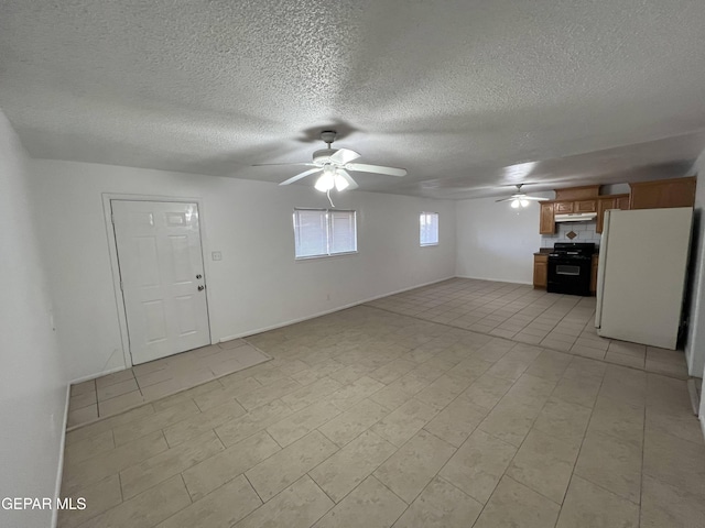 interior space featuring ceiling fan, light tile floors, and a textured ceiling