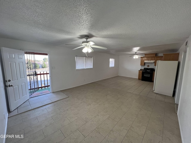 unfurnished living room with a textured ceiling, ceiling fan, and light tile floors