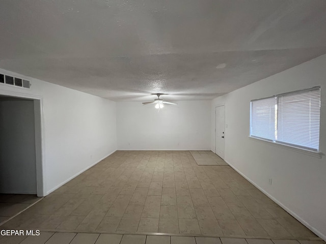 tiled spare room featuring ceiling fan